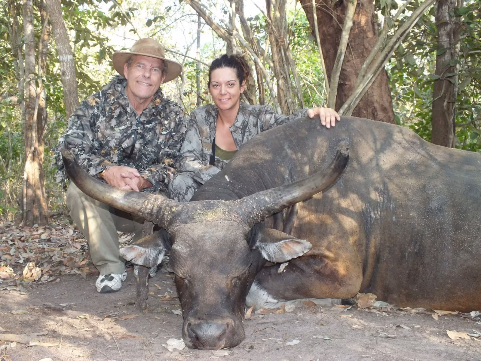 Two hunters with a wide-horned buffalo bull