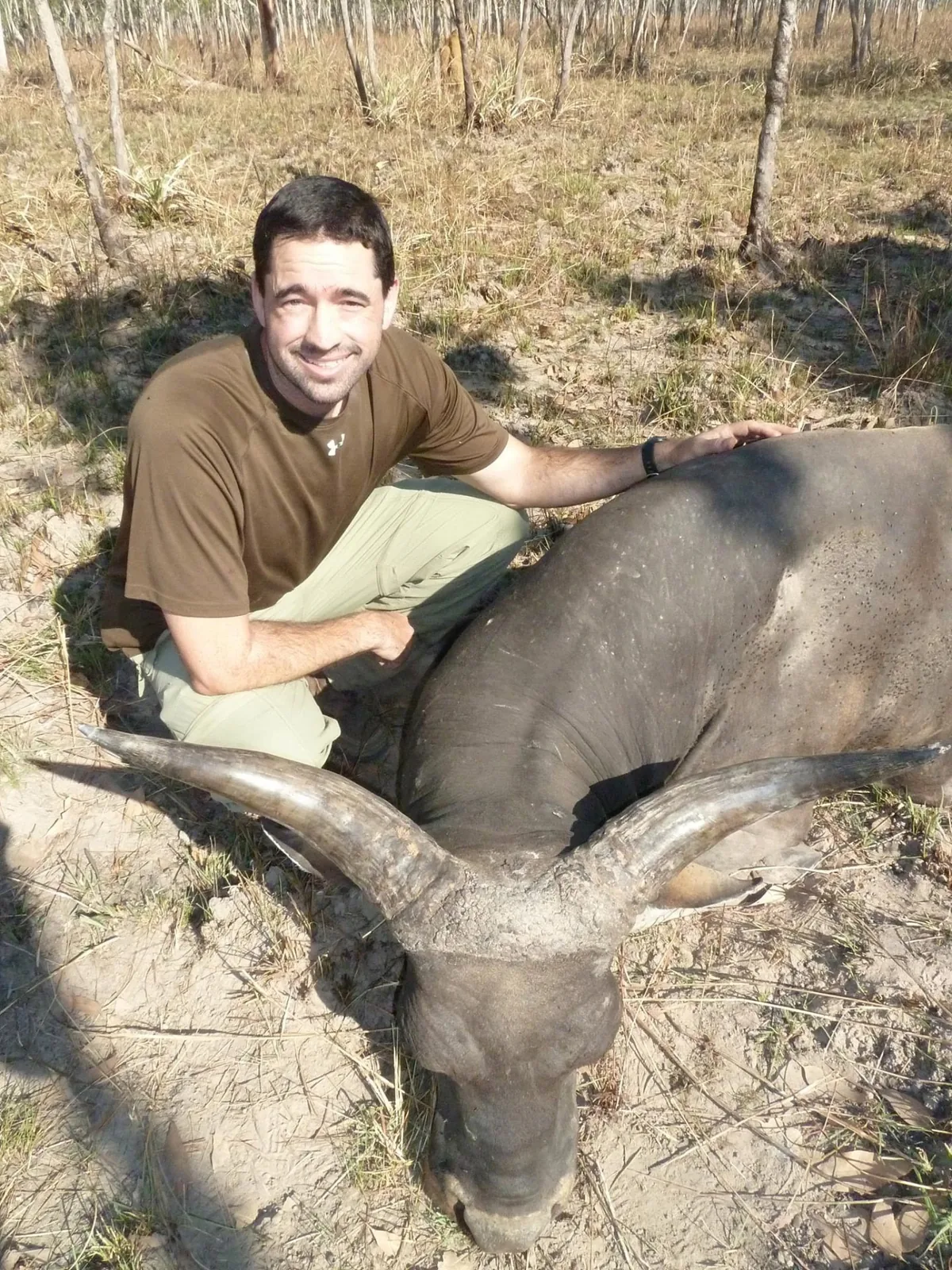 Hunter with a buffalo bull on the floodplain edge