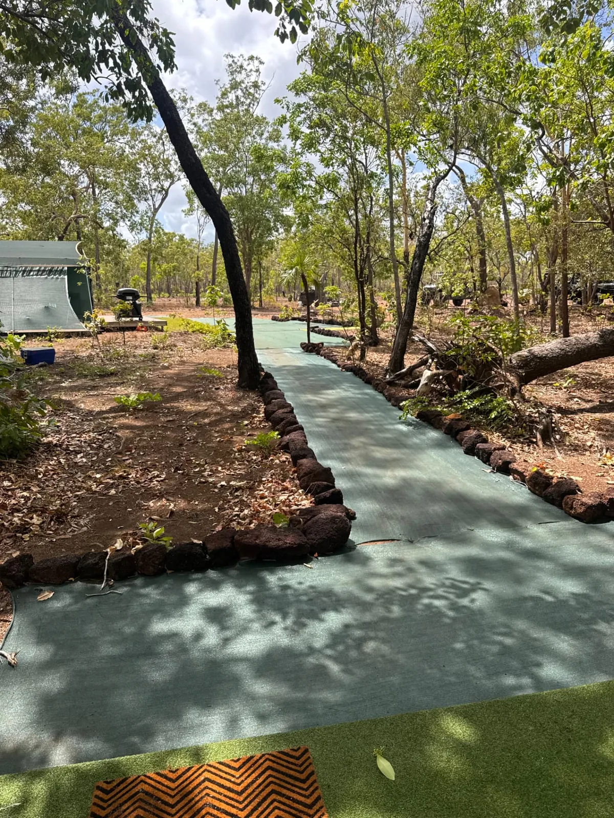Shaded pathway through camp between the pods and mess tent