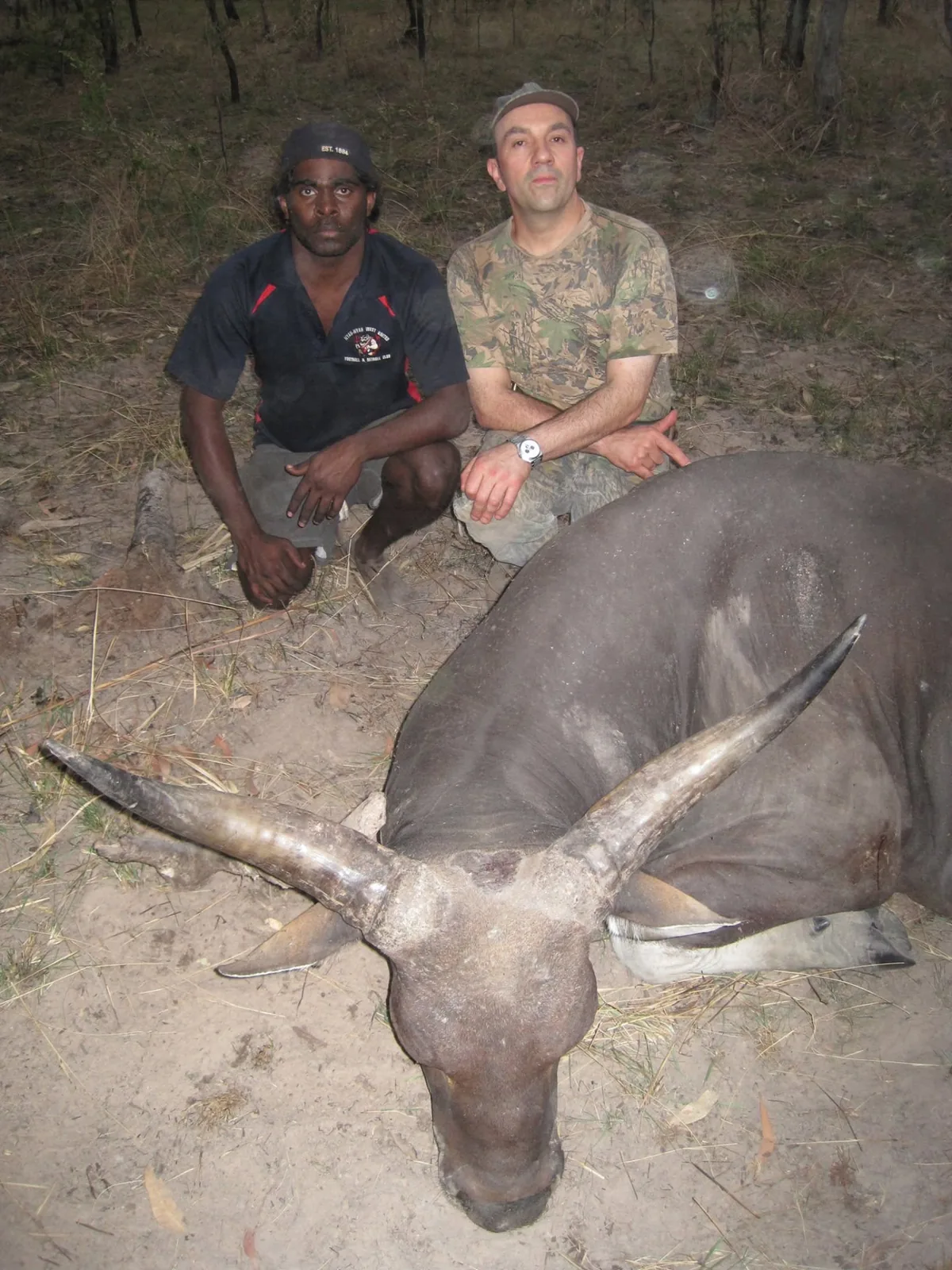 Guide and hunter with a banteng bull taken at dusk